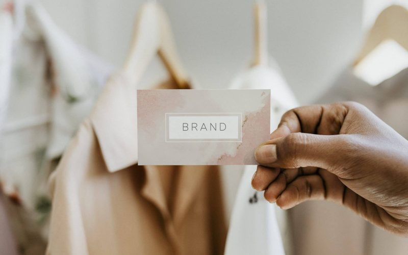 Hand holding business card at a boutique